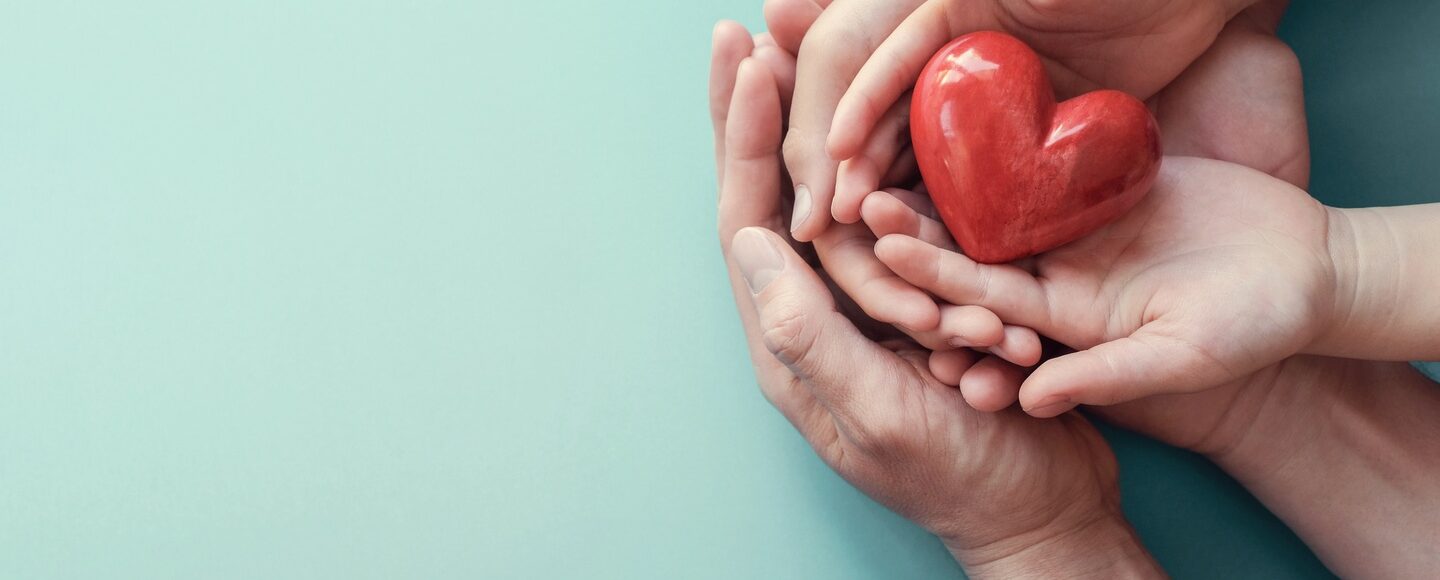 Hands holding a heart shaped apple for World Health Day