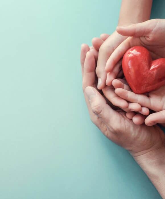 Hands holding a heart shaped apple for World Health Day