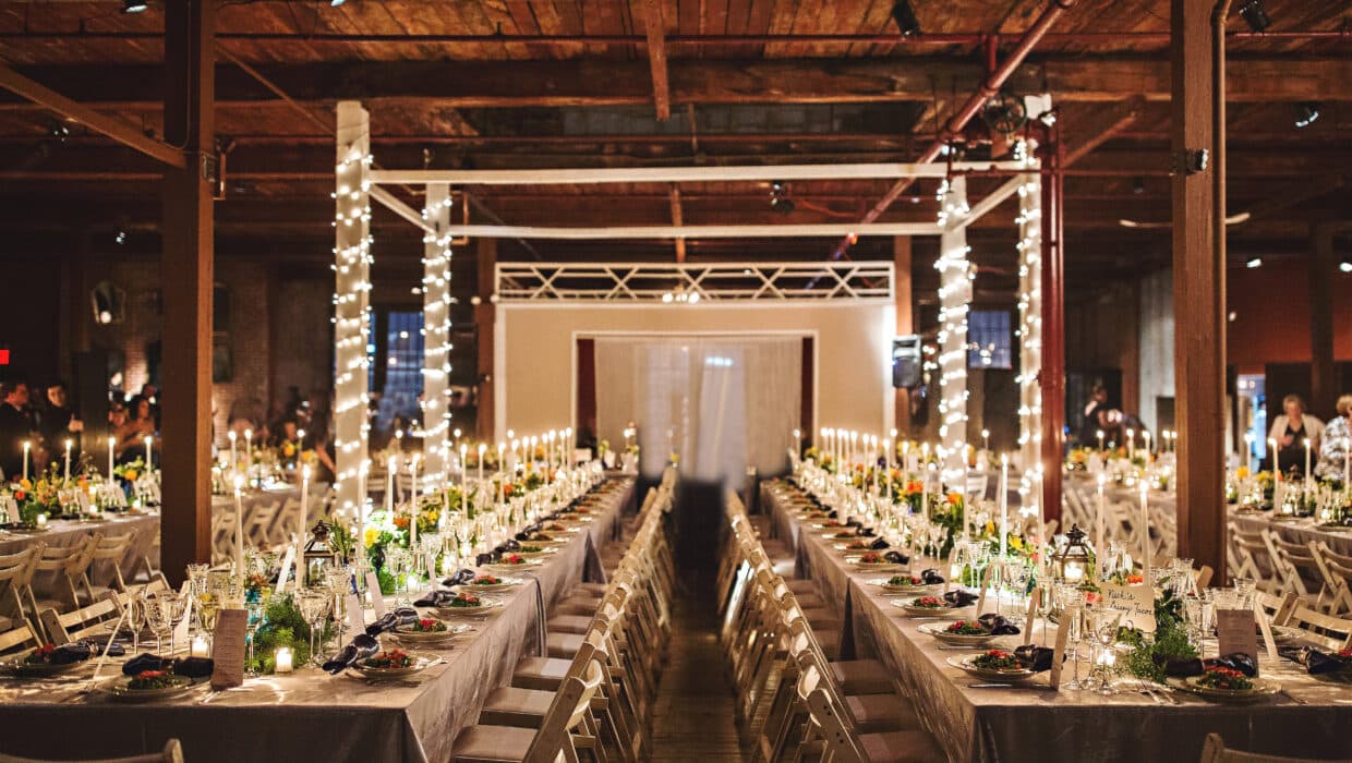 Full room shot with candles lite, long long tables