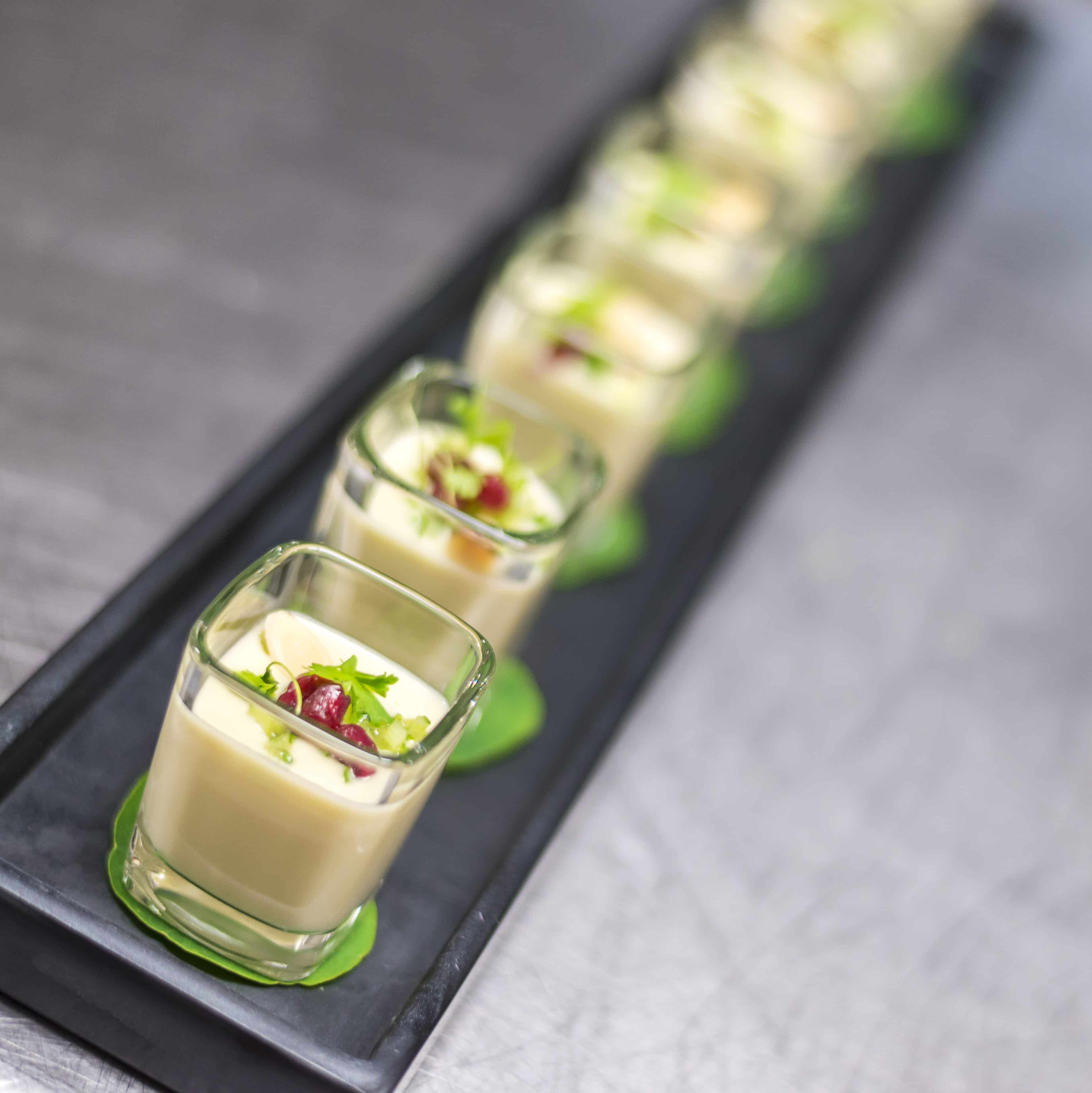 Passed Hors d'Oeuvre in individual glass shooters on a black tray